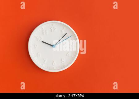 White wall Clock on red background. Stock Photo