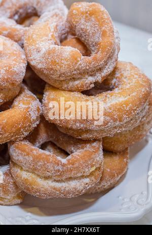 Spanish fritter donuts or roscas fritas. Dusted with sugar and plated in porcelain dish Stock Photo