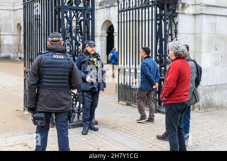 Tourists chat to armed police at the gates of Horseguards, Whitehall, London, UK Stock Photo