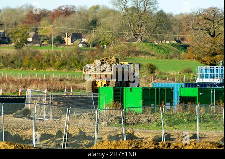 Aylesbury, UK. 25th November, 2021. HS2 construction work gathers pace on former farmland compulsorily purchased by HS2 in Aylesbury. A haul road is being built at the site off the Oxford Road and huge dumper trucks regularly cross one of the few public footpaths that HS2 haven't closed off. Although the Eastern Leg of the HS2 High Speed Rail has been cancelled by Boris Johnson, HS2 Ltd are continuing with their construction of Phase 1 of the HS2 High Speed Rail from London to Birmingham which is destroying swathes of the Chilterns, an Area of Outstanding Natural Beauty. Credit: Maureen McLean Stock Photo