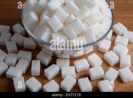 White sugar cubes in glass bowl,on wooden background Stock Photo