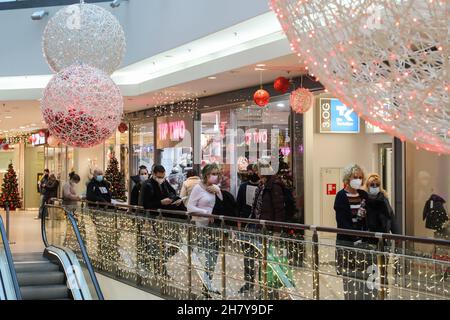 Berlin, Germany. 25th Nov, 2021. People line up to get inoculated with COVID-19 vaccines at a vaccination station inside a shopping center in Berlin, Germany, Nov. 25, 2021. The total number of COVID-19 deaths in Germany has climbed to 100,119, as 351 fatal cases were recorded within the last 24 hours, the Robert Koch Institute (RKI) announced on Thursday. Credit: Shan Yuqi/Xinhua/Alamy Live News Stock Photo