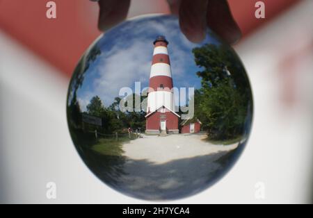Chincoteague, Virginia U.S.A - September 21, 2021 - The red and white tower of Assateague Light House captured inside a lens ball Stock Photo