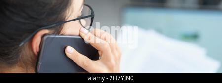 Businesswoman talking on phone and holding document in hands Stock Photo