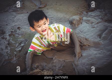 Children are playing in the mud during the quarantine days during the covid-19 pandemic when all activities are suspended for entertainment Stock Photo