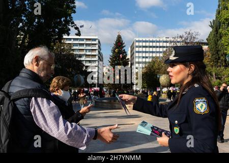 Athens, Greece. 25th Nov, 2021. A policewoman gives leaflets to passersby on the International Day for the Elimination of Violence against Women in Athens, Greece, Nov. 25, 2021. Credit: Marios Lolos/Xinhua/Alamy Live News Stock Photo