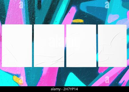 colorful urban wall with four wrinkled glued poster templates Stock Photo
