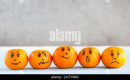 Mandarin emoji, tangerine with painted faces. Different emotions, characters: kind, angry, sad, smile, happy, crying. Copy space Stock Photo