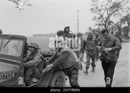 HUE, VIETNAM - 20 February 1968 - Walter Cronkite (centre-right holding microphone) and a CBS camera crew use a jeep for a dolly during an interview w Stock Photo