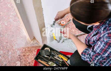 Female plumber doing heating installation on a construction site Stock Photo