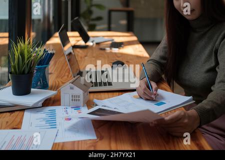 Business Woman Financing Accounting Banking Concept, businesswoman doing finances and calculate about cost to real estate investment and in other, tax Stock Photo