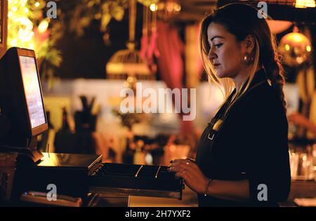 a beautiful young woman at the desk in a restaurant Stock Photo