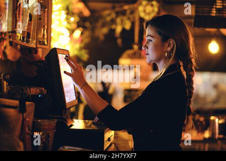 a beautiful young woman at the desk in a restaurant Stock Photo