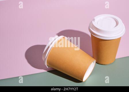 Two paper disposable cups for hot coffee and tea on pink green background .Concept and trend of takeaway food Stock Photo