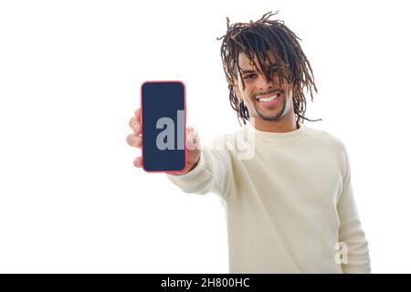 Latin man showing blank screen mobile phone to camera while standing on isolated background. Stock Photo