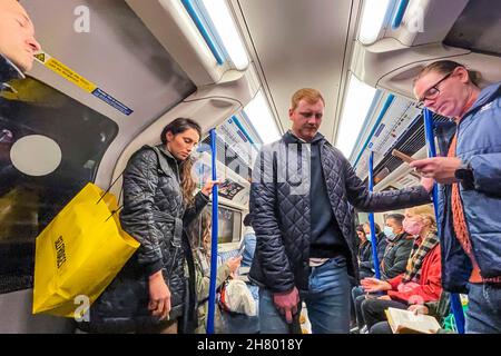 London, UK. 25th Nov, 2021. Mask confusion continues on the underground. The tube is busier and masks are still obligatory but increasing numbers are ignoring the instruction led by mixed messages from the government. Credit: Guy Bell/Alamy Live News Stock Photo