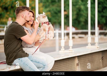 young couple in a bridge with their dog in an urban scene Stock Photo