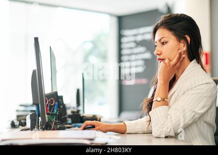young latin businesswoman working at her office Stock Photo