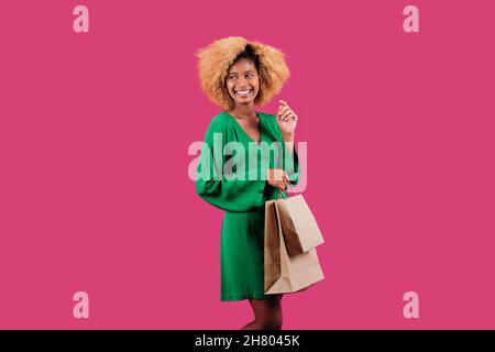 Smiling woman holding eco friendly shopping bags. Black friday sales season. Stock Photo