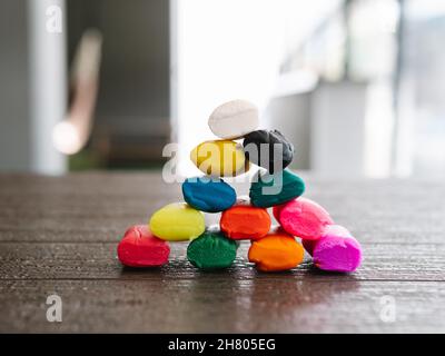Blocks of soft colorful plasticine stacked in a pyramid shape on wooden table Stock Photo