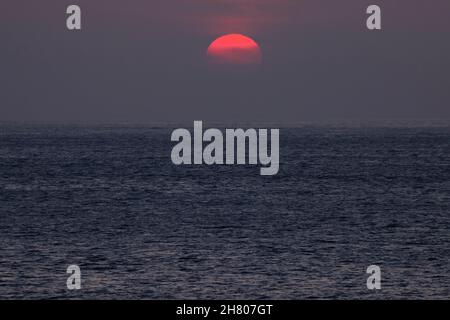 Picturesque scenery of bright orange sun setting over wavy ocean in La Palma Island Stock Photo