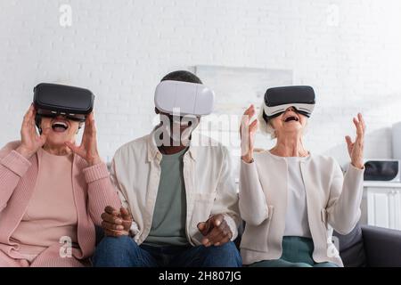 Cheerful interracial pensioners using vr headsets in nursing home Stock Photo