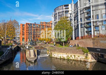 Gasholders luxury apartment buildings and St Pancras lock people on Regents Canal towpath in autumn sunshine Kings Cross London N1C UK    KATHY DEWITT