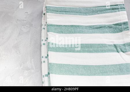 Striped green and white kitchen towels on gray background, top view, copy space Stock Photo