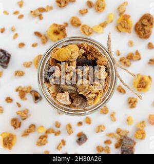 crunchy granola in glass jar isolated on white background, top view, healthy breakfast concept Stock Photo