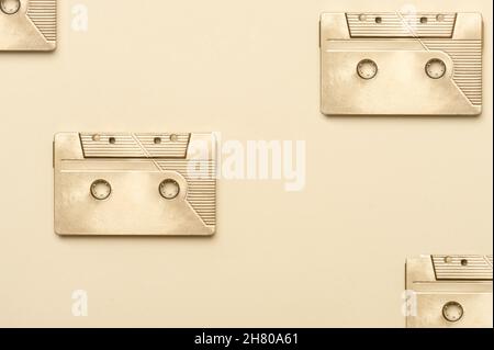 Gold fancy retro old audio cassettes tape on beige color background. Retro mixtape, 1980s pop songs tapes and stereo music cassettes Stock Photo