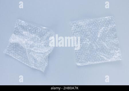 Bubble wrap bags for packaging on light blue background. Closeup, texture background, plastic pollution concept Stock Photo
