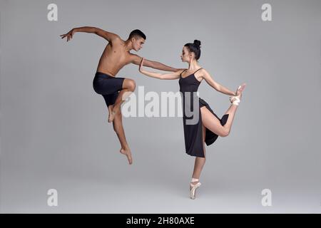Premium Photo | Two athletic modern ballet dancers are posing against a  gray studio background