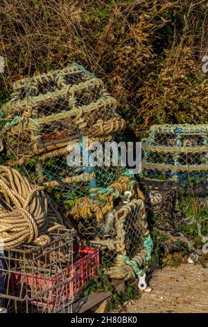 lobster and crab pots in pile on the quayside, fishing nets and traps on the harbour side, fishing equipment, fishermens gear, lobster traps, nautical Stock Photo
