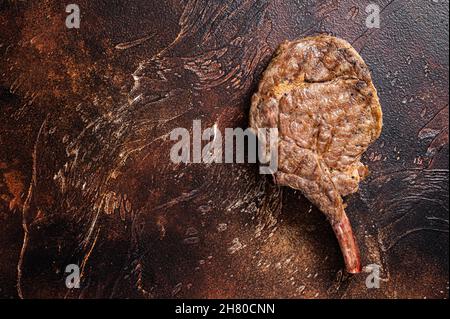 Beef Steak on the bone tomahawk, rib eye. Dark background. Top view. Copy space Stock Photo