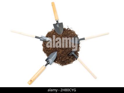 Selection of miniature garden hand tools in a soil pile isolated on white background. Stock Photo