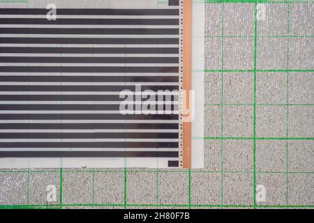 A roll of film underfloor heating lies on the insulation Stock Photo