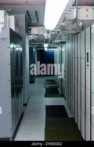 closed servers in data center with fluorescent lamps, cyber security concept Stock Photo