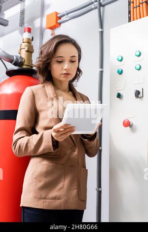 engineer using digital tablet near switchboard in data center Stock Photo