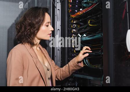 technician checking wires in server while working in data center Stock Photo