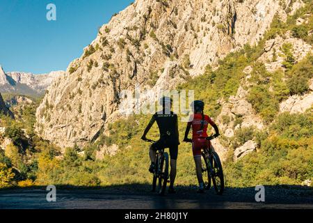 Kemer, Turkey - November 11, 2021: couple of cyclists look at a beautiful mountain valley