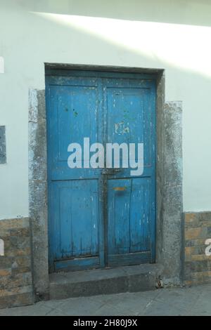 Cuzco Peru centre of town centre door old wood wooden blue worn closed bolted painted paint flaking step paint repaired repair history historic style Stock Photo