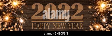 HAPPY NEW YEAR 2022, golden bokeh flares and sparkler isolated on rustic brown wooden texture - Holiday New Year's Eve Party festive background banner