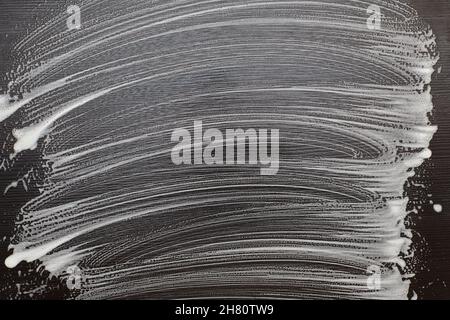 Soap foam on a black table. Foam traces on black background. Copy space. Stock Photo