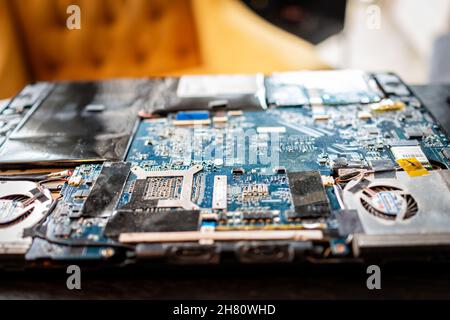 Banner Elk, USA - June 23, 2021: Macro closeup of dusty dust micro chips in motherboard of open laptop computer keyboard for replacing dead hard drive Stock Photo