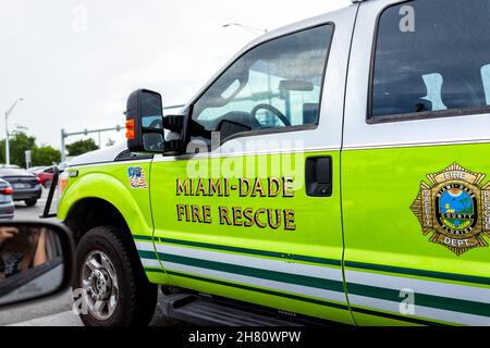 Miami, USA - July 23, 2021: Sign for Miami-Dade county fire rescue on truck in Florida in downtown traffic with neon green yellow color on car Stock Photo