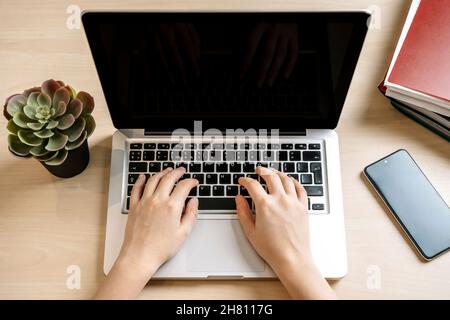 Laptop and hands on workplace background. Typing text on a computer keyboard on a desktop table in office or home. Computer web technology, sales, internet, marketing concept. High quality photo Stock Photo