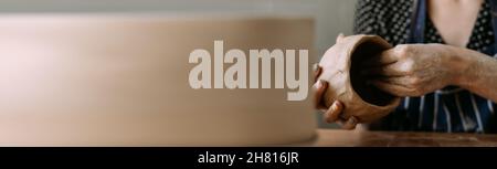 Modeling from clay or ceramics female hands making a vase. Clay sculpting. Banner Stock Photo
