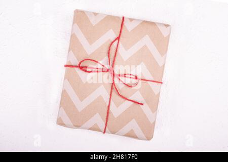 gift with red rope on white background top view, birthday new year christmas. Stock Photo