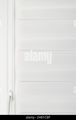 White  roller day and night blinds on pvc window Stock Photo