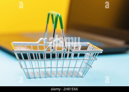 Empty grocery basket on laptop background, online shopping concept Stock Photo